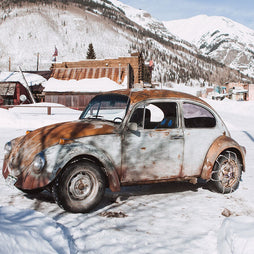 Winter Wonderland Beauty: Scenic Photo of Vintage Beetle in a Quaint Snowy Mountain Village